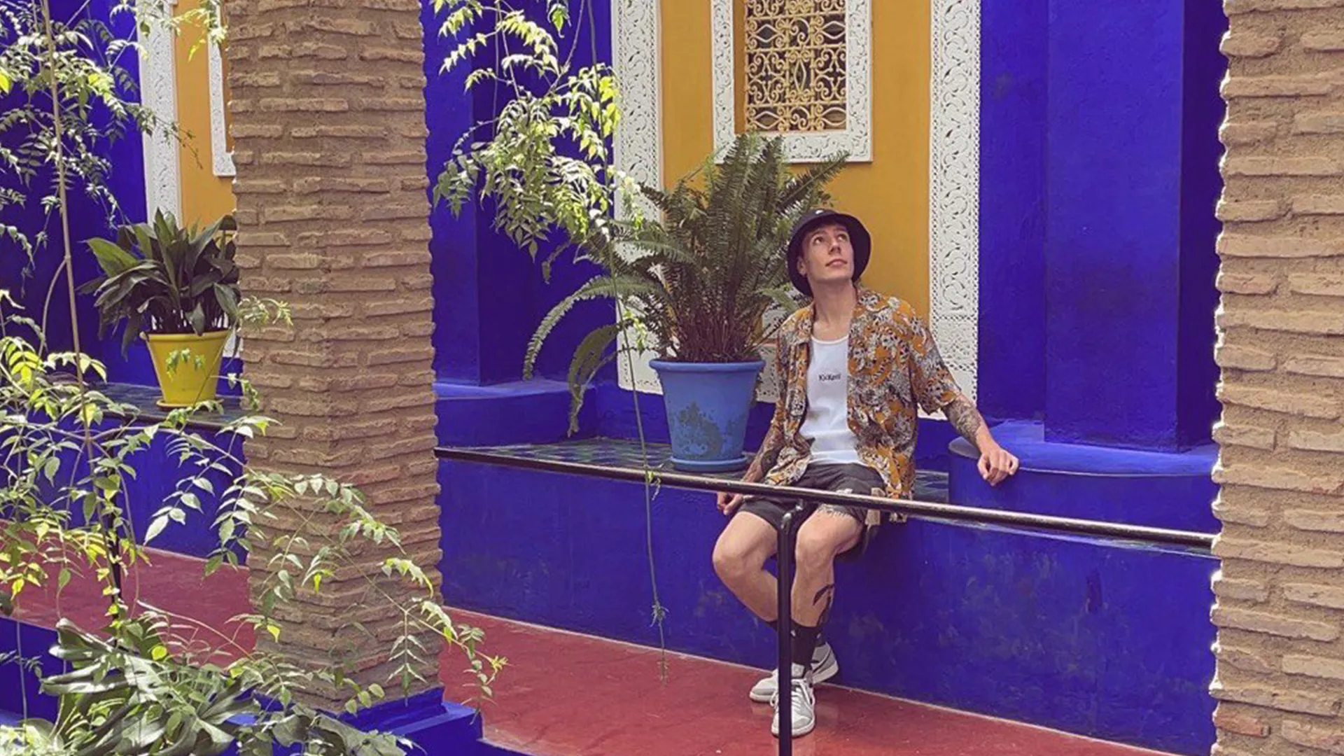 Eric Avito sentado en un patio azul
